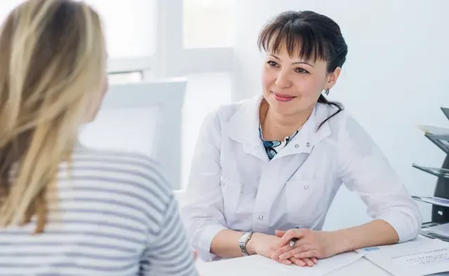 Adult Gerontology nurse practitioner smiling during appointment with patient